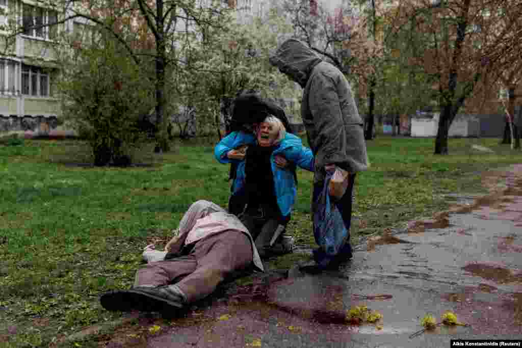 Яну Бачек утешают ее муж Евгений Власенко и ее мать Любовь Губарева, когда она плачет около тела своего отца, 79-летнего Виктора Губарева. Он погиб в результате обстрела в Харькове 18 апреля 2022 года.