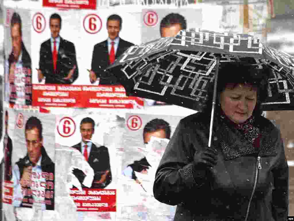 Caption: epa01212439 An elderly Georgian woman walks past electoral posters in Tbilisi, Georgia, 02 January 2008. Early presidential elections in Georgia are scheduled on 05 January 2008