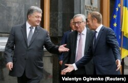 Президент Украины Петр Порошенко (слева), глава Еврокомиссии Жан-Клод Юнкер (в центре) и председатель Европейского совета Дональд Туск