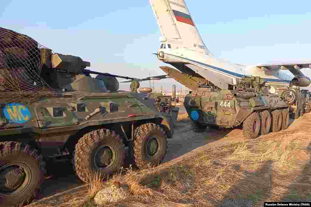 Военная техника рядом с самолетом во время того, как российские миротворцы прибывают в аэропорт под Ереваном 11 ноября. Объявление о прекращении огня вызвало празднования в Азербайджане, а в Армении &mdash; гневные протесты, демонстранты штурмовали правительственные здания и парламент