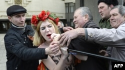 Активистка группы Femen пытается выхватить микрофон во время пророссийского митинга в Симферополе