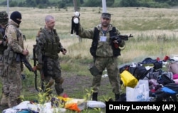 Боец самопровозглашенной "ДНР" показывает игрушку, принадлежавшую кому-то из погибших детей, летевших рейсом MH17. 18 июля 2014 года