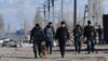 Kazakhstan - Police officers walk along road in the village of Blas-Batyr some 250 kilometres from Almaty on February 8, 2020. - Eight people were killed, dozens hurt and property burned during clashes between ethnic Kazakhs and members of the Dungan mino